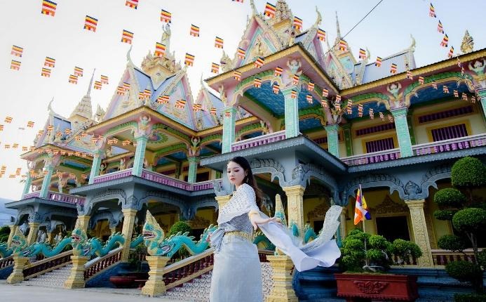 A person in a white dress in front of a colorful building
AI-generated content may be incorrect.